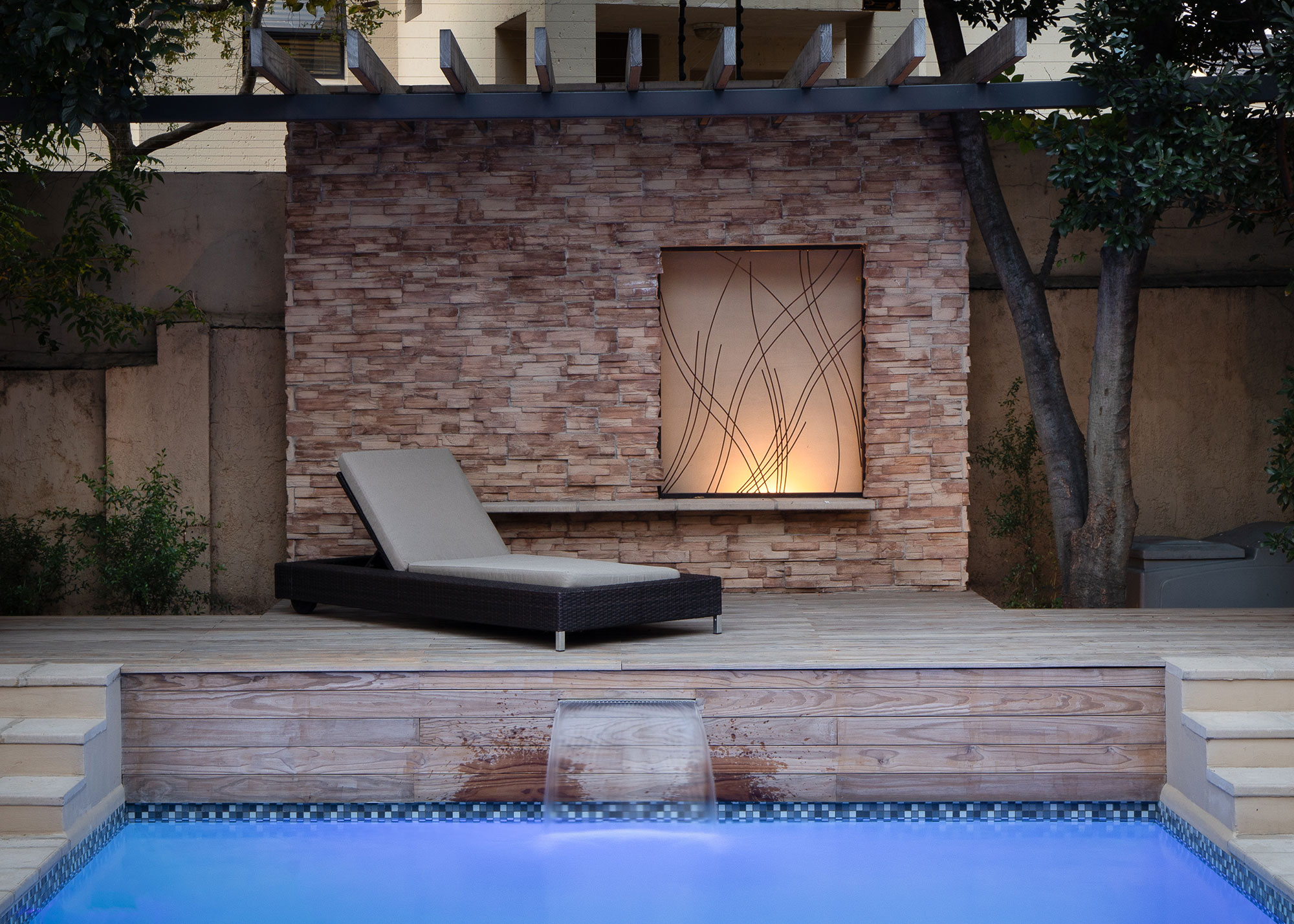 Garden design - Poolside deck with water feature and pergola